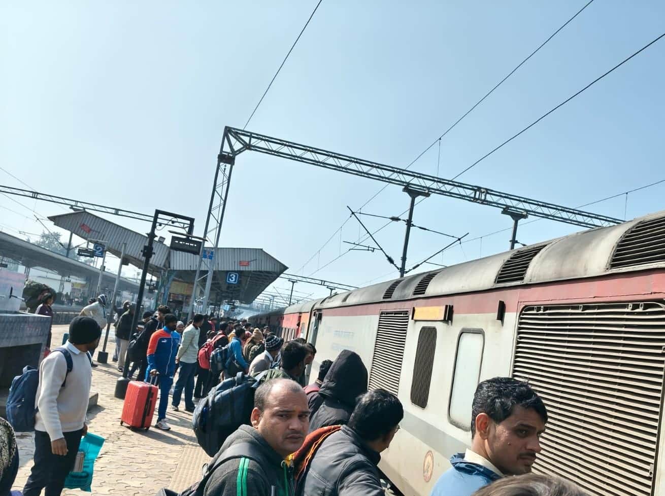 रेवाड़ी रेलवे स्टेशन पर ट्रेन पकड़ने के लिए खड़े यात्री। संवाद