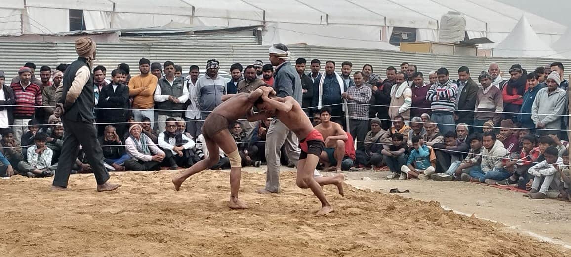 दगंल के दौरान दाब पेच आजमाते पहलवान। संवाद