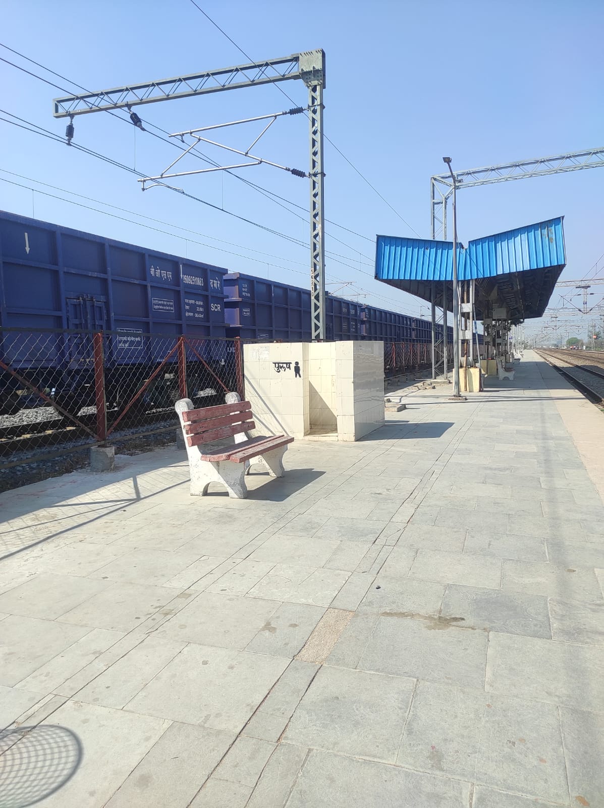 A freight train was parked between the station and the crossing.
