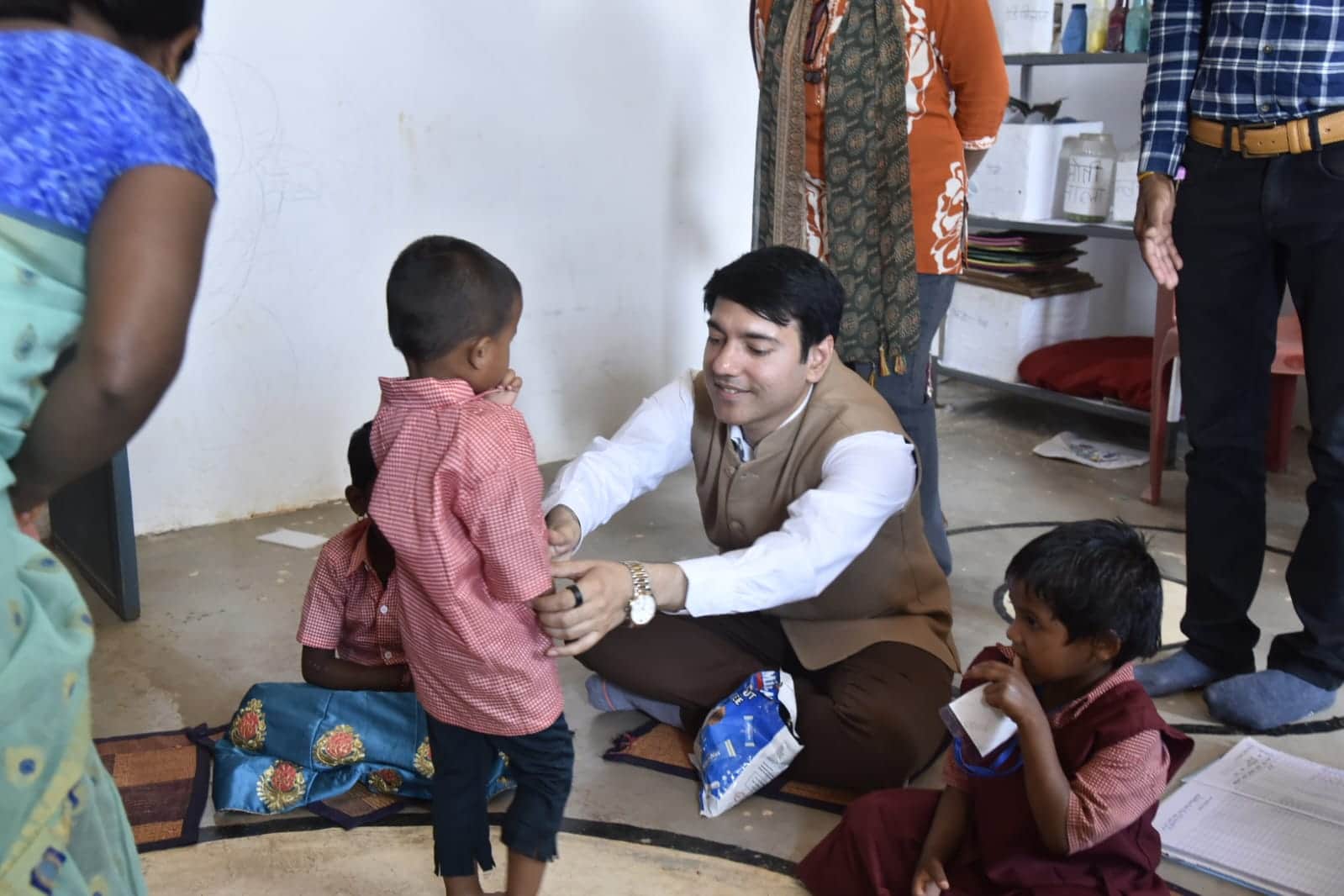 बच्चों के बीच जमीन पर बैठे कलेक्टर