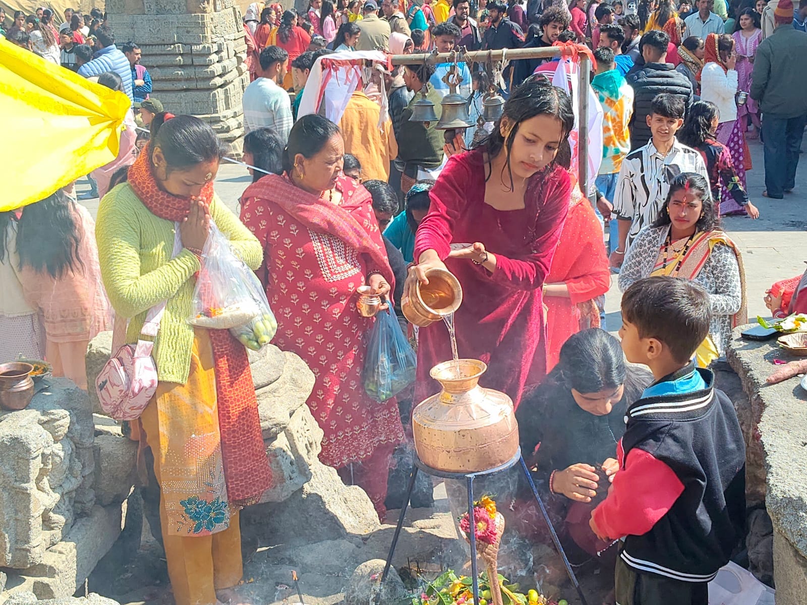 चंपावत के बालेश्वर महादेव मंदिर में जलाभिषेक करती युवती। संवाद
