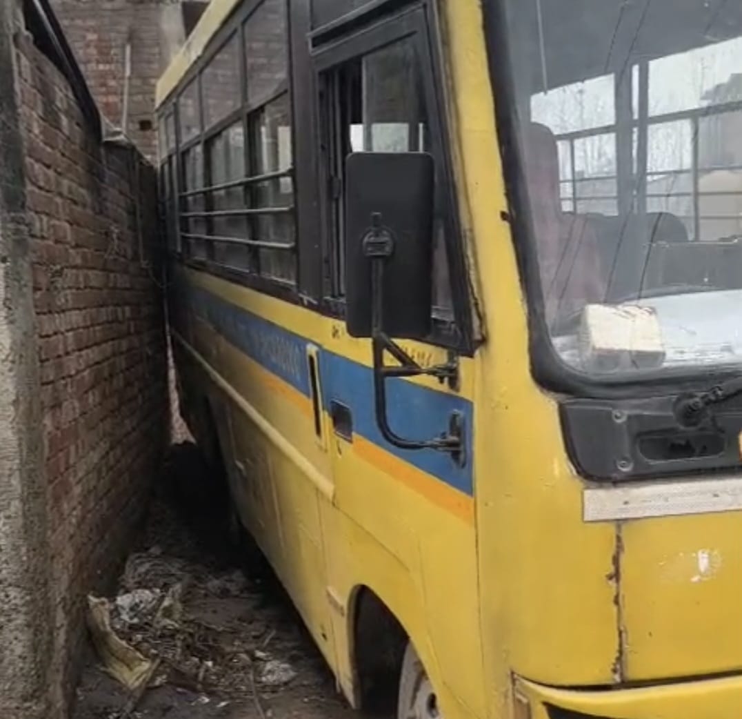 School bus stuck due to broken drain and encroachment on the road