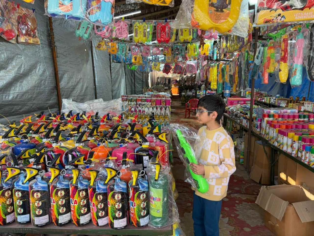 The market is abuzz with colourful squirt guns and gulal.