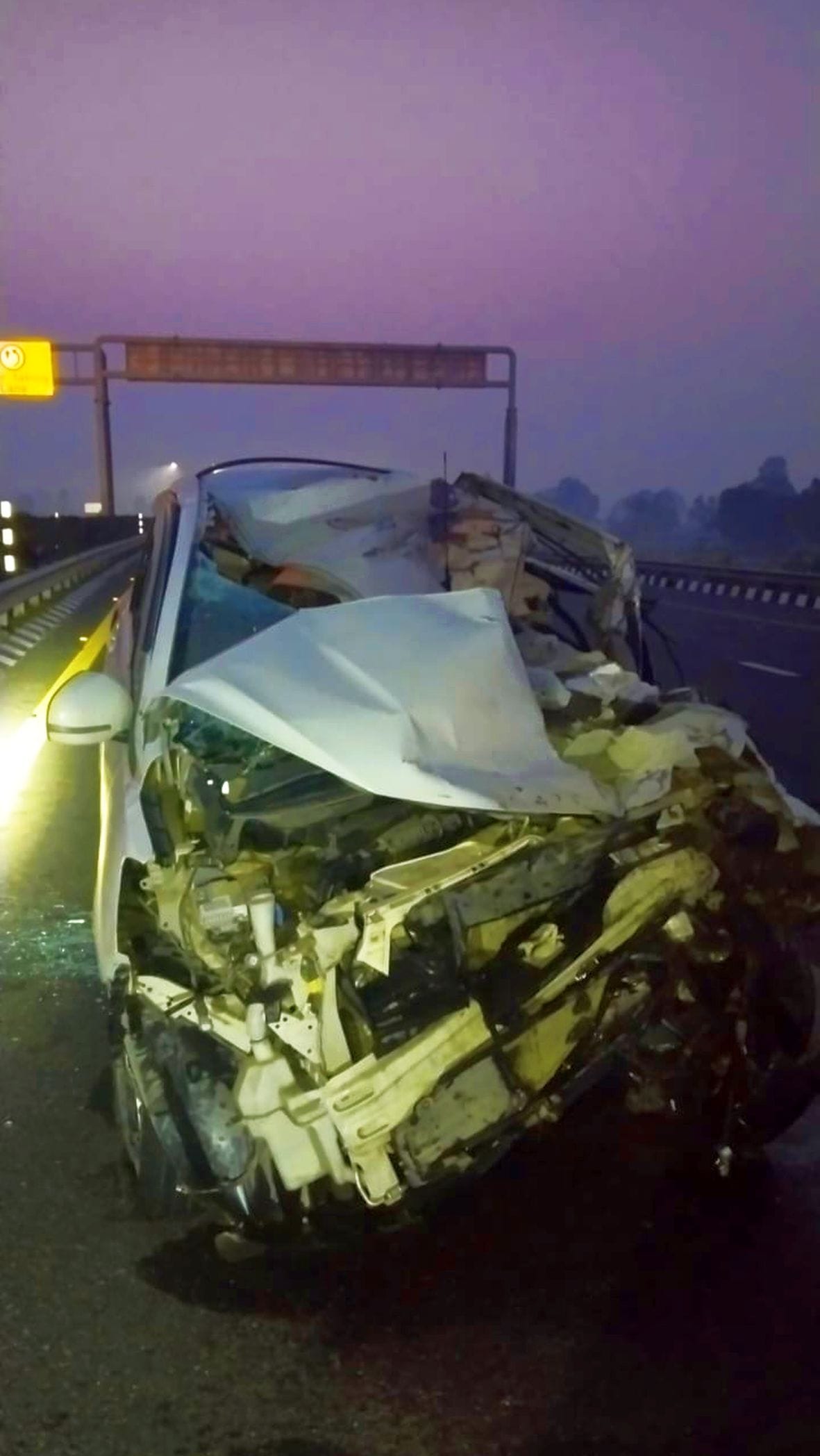 Car damaged after being hit by truck, four injured