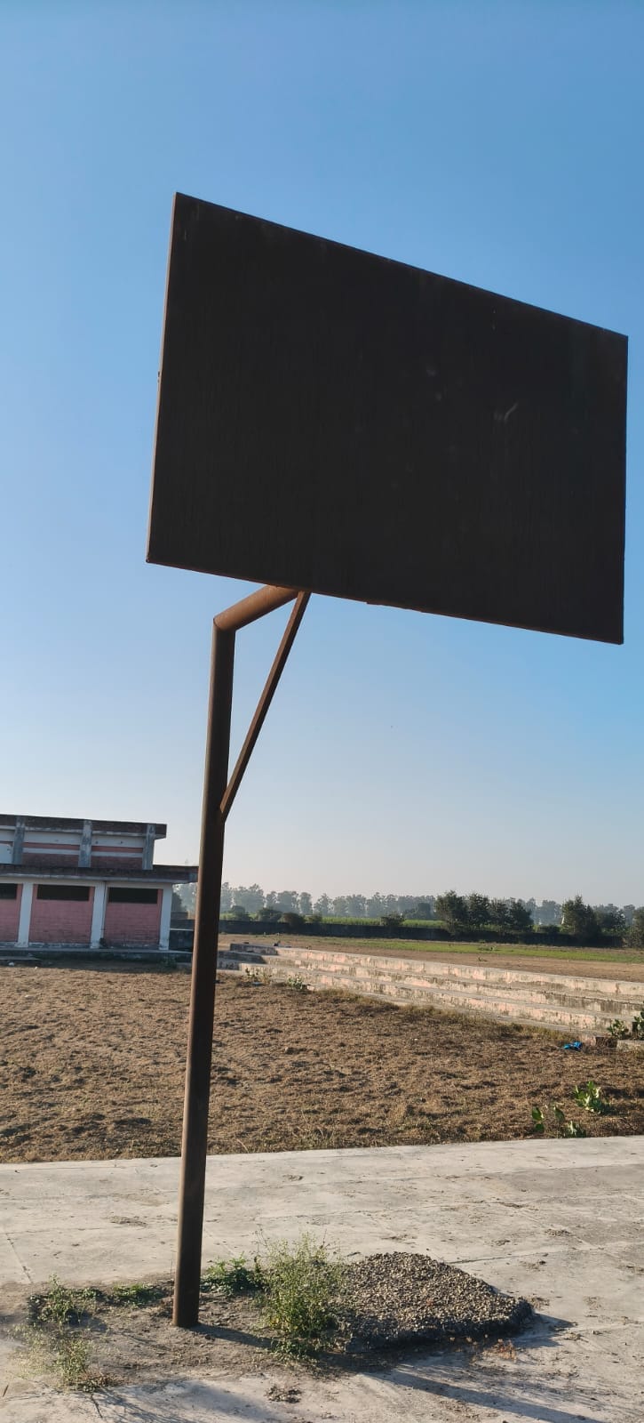 The track at Ghogharipur playground is in a bad state, and the field itself is covered in tall grass.