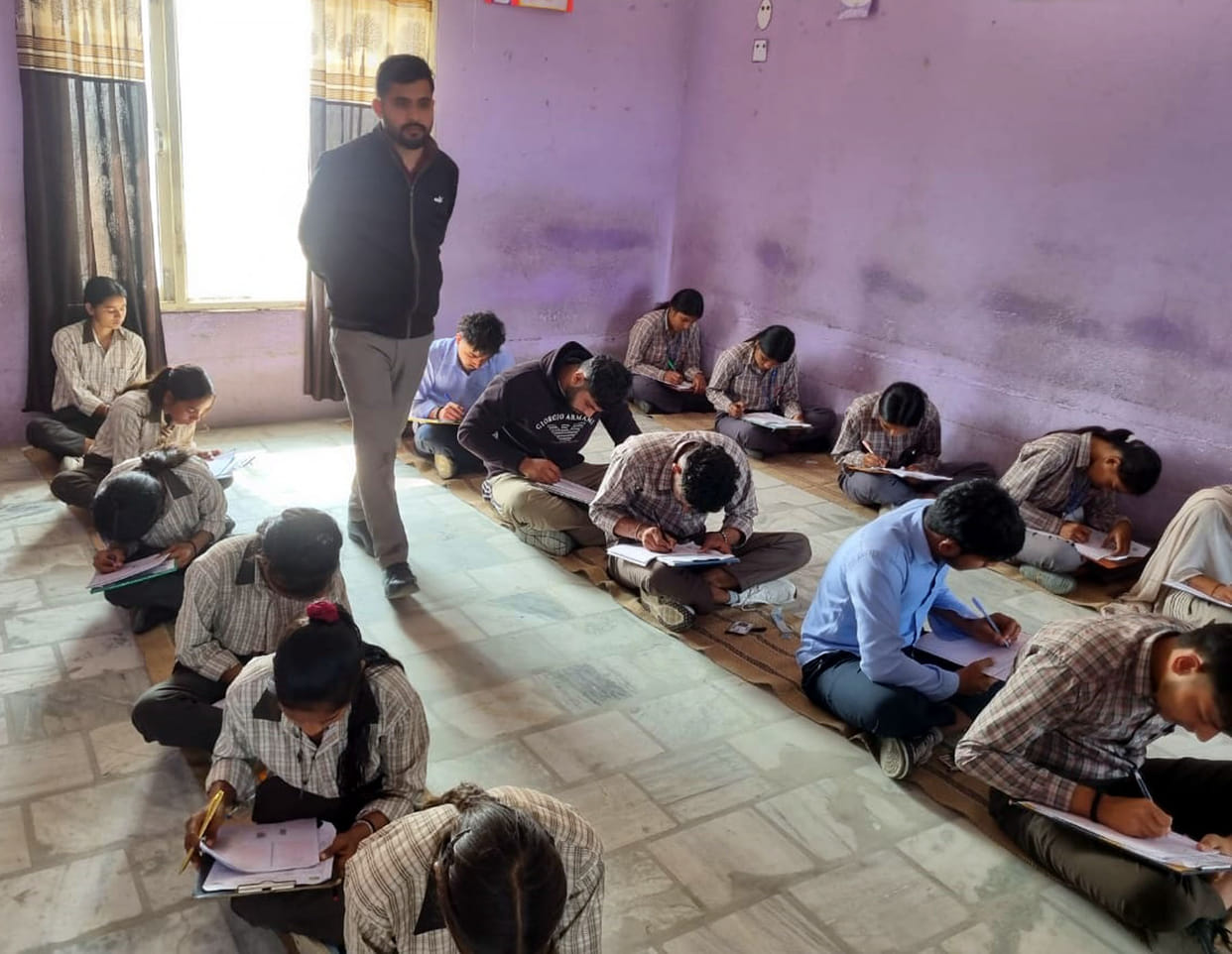 At the examination center in Badsikri village, children sat on mats to take the board exam.