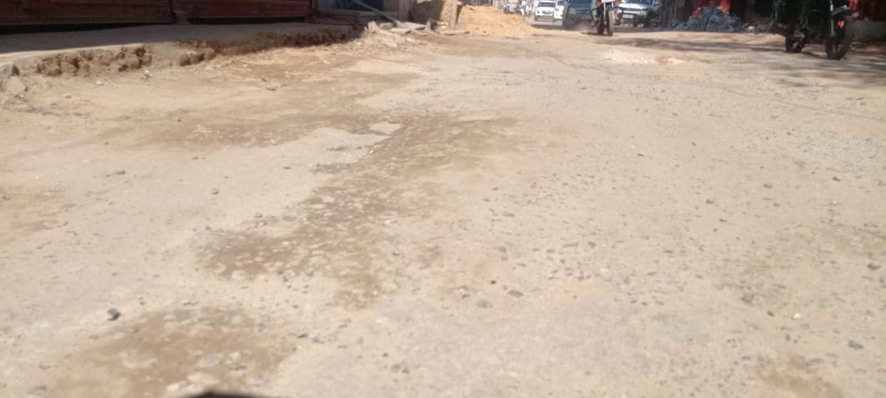 The road, built four years ago, is in a dilapidated condition, and people are jostling over potholes.