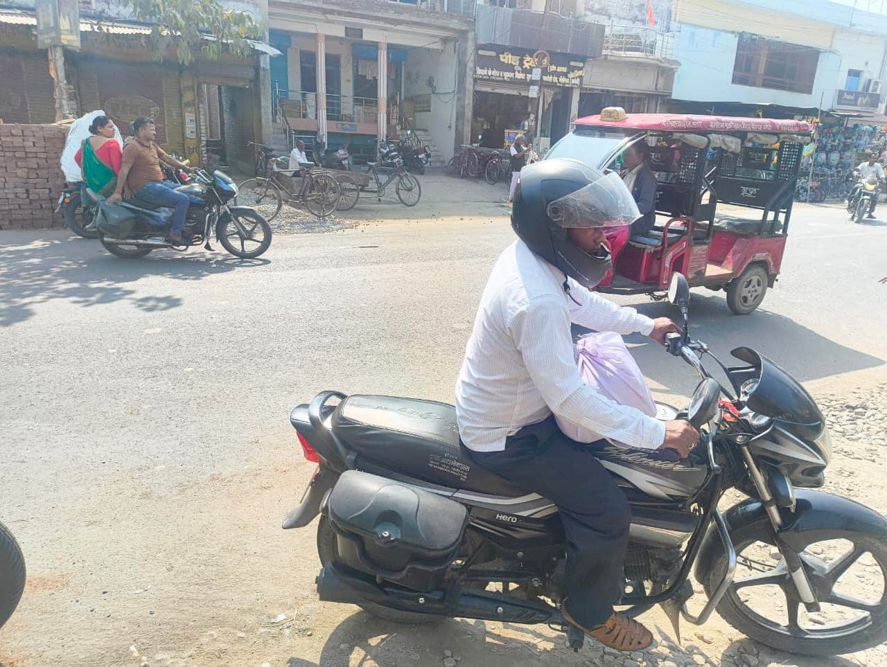 जीजीआईसी मोड़ पर बाइक से काॅपी का बंडल संकलन केंद्र ले जाते शिक्षक।