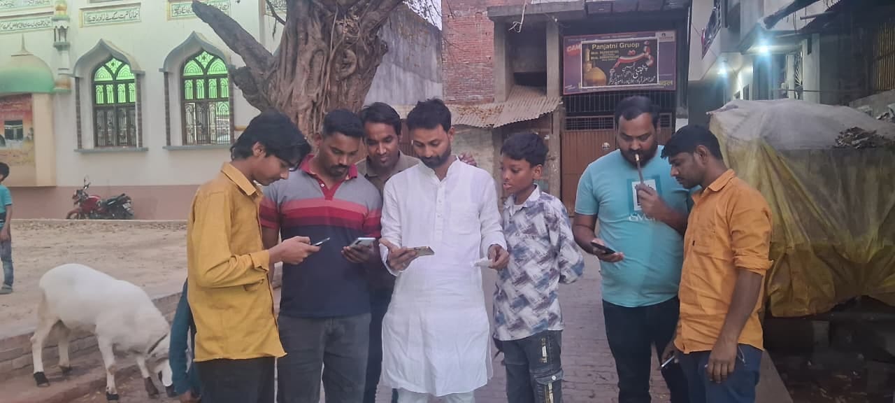 जलालपुर के अखाड़ा जाफराबाद में ईरान पर हमले की मोबाइल पर खबर देखते युवा
