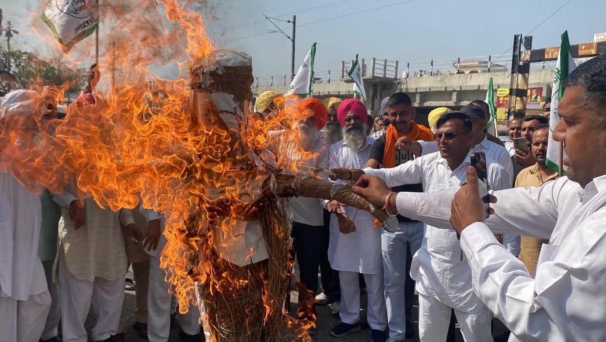Farmers burn effigies of Prime Minister Modi and US President Trump in protest against the trade deal.
