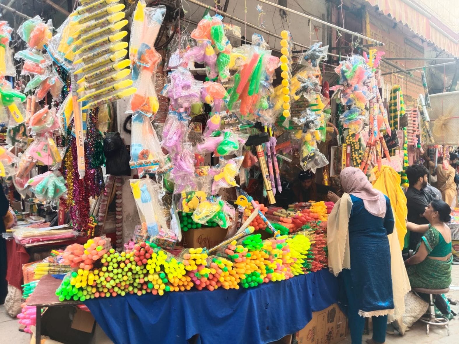 शहर के मुरारीदास गली में सजी पिचकारी की दुकानें।  