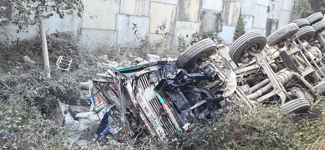 The truck broke the toll barrier and overturned 20 feet down in the garden, injuring the driver and cleaner
