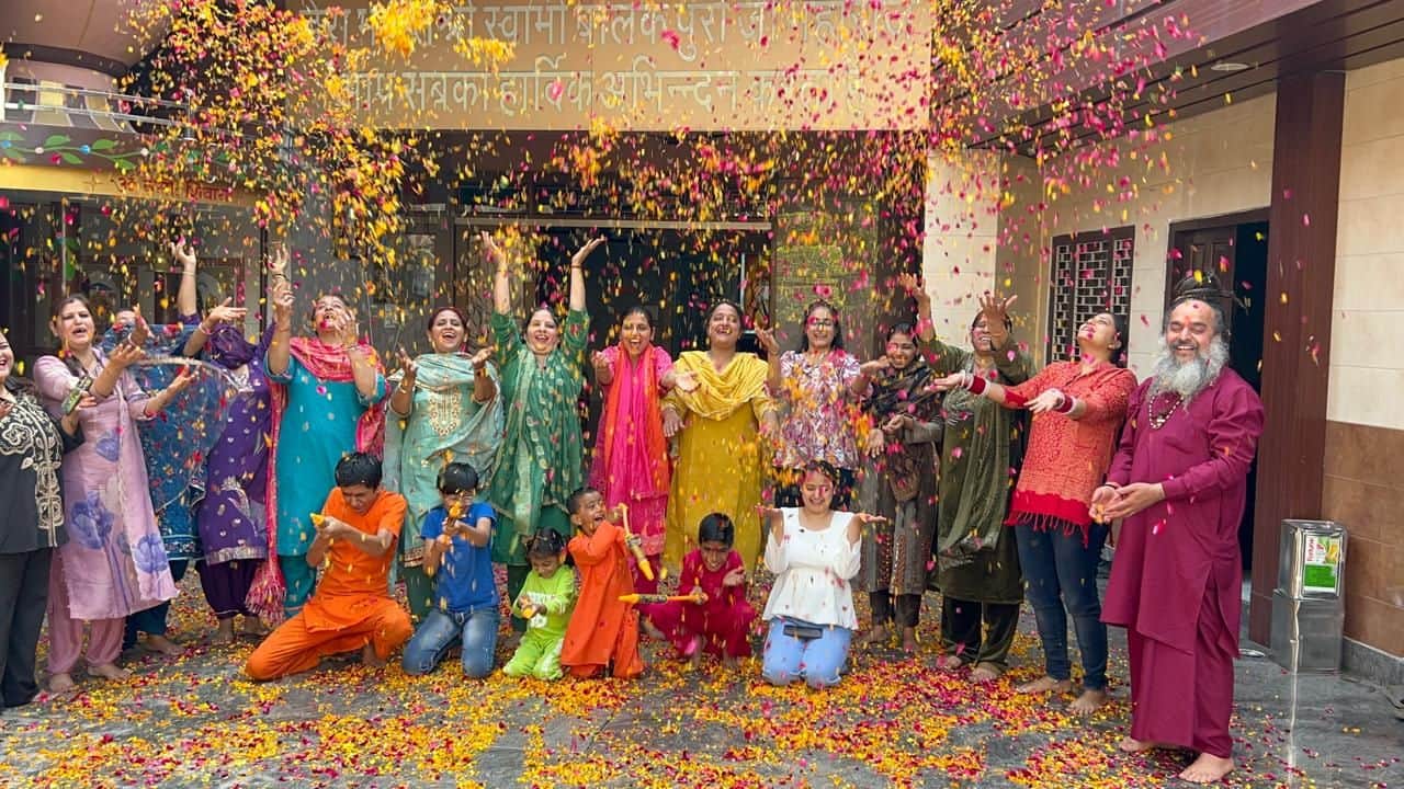 18-बाबा बालक पुरी डेरे में फूलों की होली कार्यक्रम में एक-दूसरे पर पुष्प वर्षा करते हुए श्रद्धा