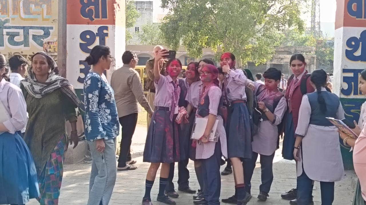परीक्षा के बाद रंगों में रंगी छात्राएं सेल्फी लेती हुईं। 