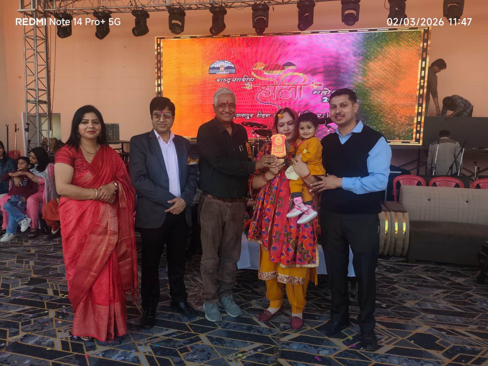 राष्ट्र स्तरीय होली उत्सव में आयोजित बेबी शो में बेहतर प्रस्तुति देने वाले प्रतिभागी को सम्मानि