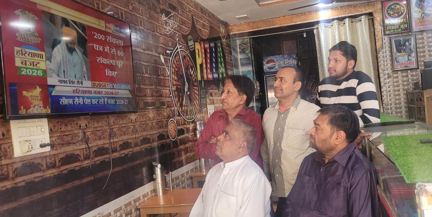 टीवी पर बजट देखते व्यापार मंडल के सदस्य।