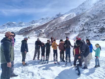 Young people are seen falling on the snow, recovering and then moving forward.