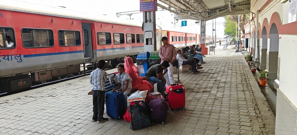 People returning after celebrating Holi have to wait for the bus.