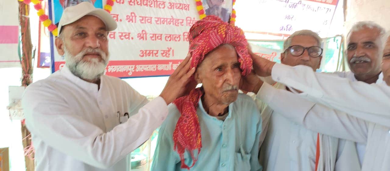 रेवाड़ी। राव रामेश्वर सिंह को धरने का नया अध्यक्ष चुने जाने पर पगड़ी पहनाकर सम्मानित करते ग्राम