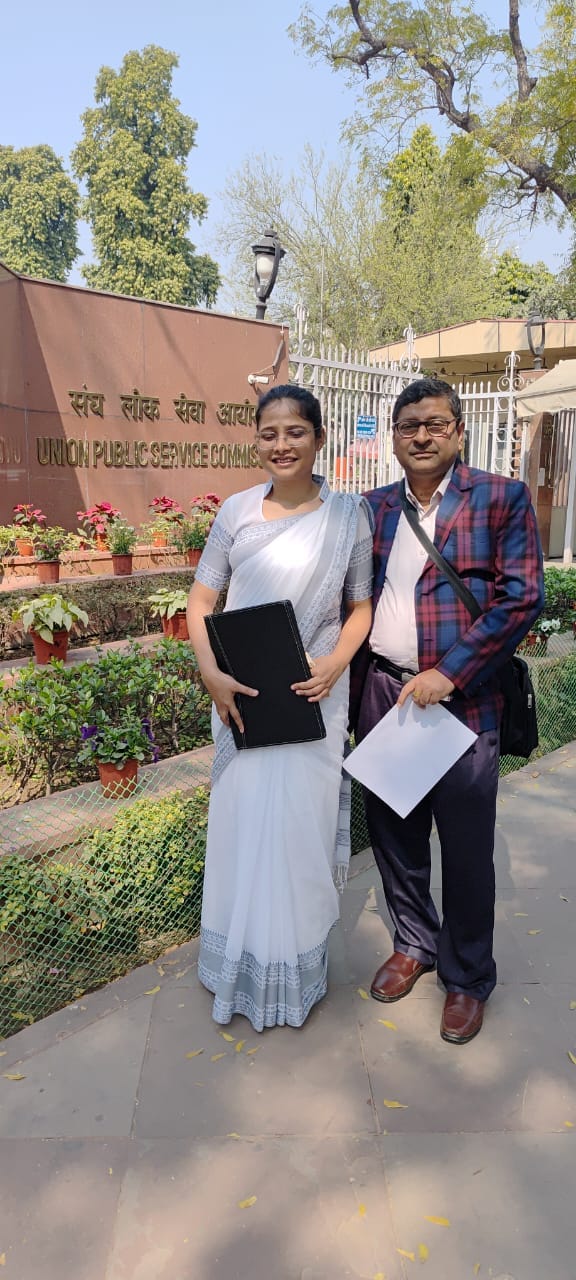 टॉपर जूही दास को मिठाई खिलाते हुए परिजन