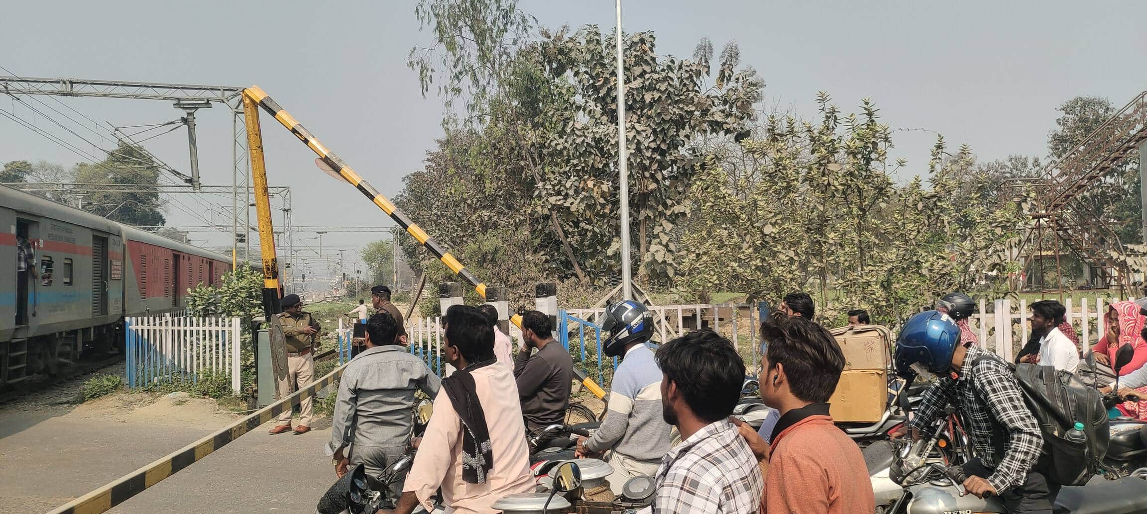 जगदीशपुर के पूरे शोहरत रेलवे क्रॉसिंग पर टूटा फाटक का बूम और मौजूद राहगीर। संवाद