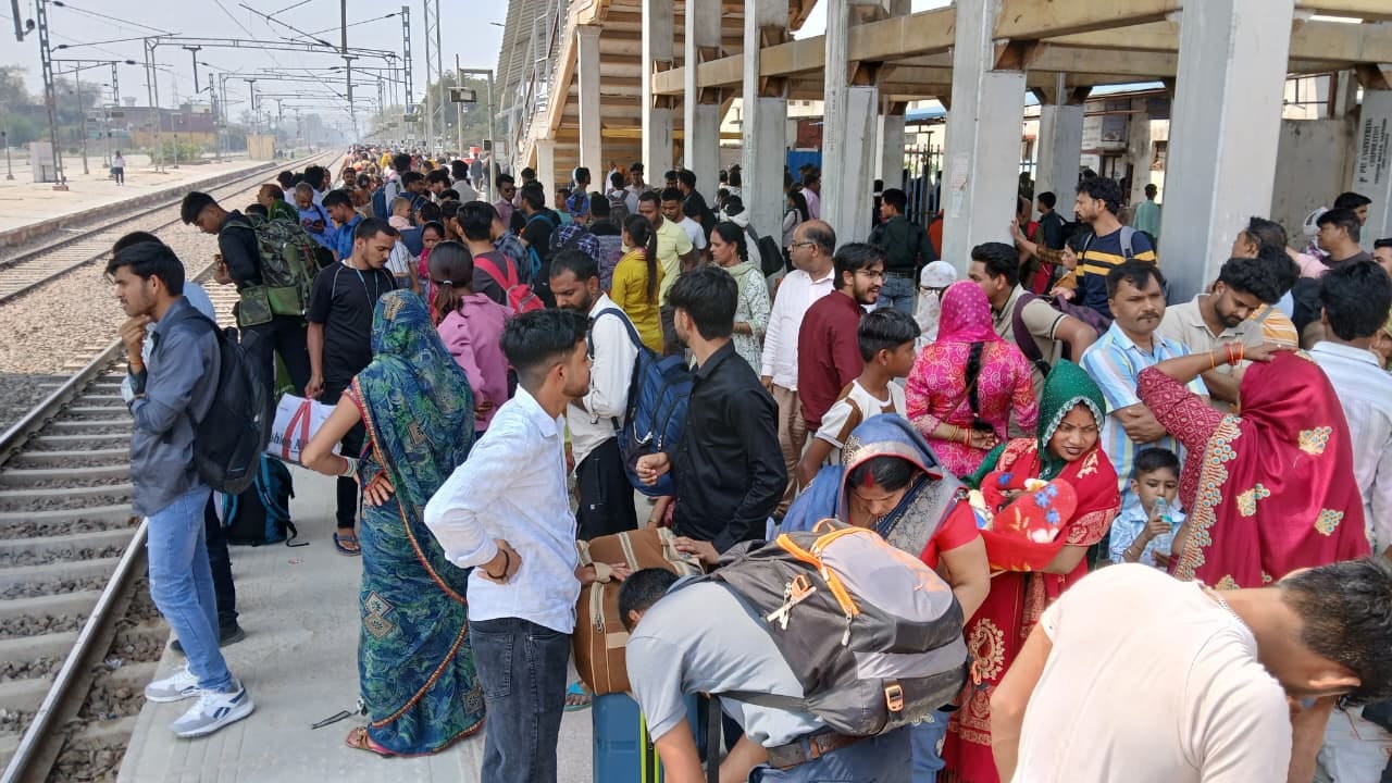 Railway station crowded with passengers, jostling for seats