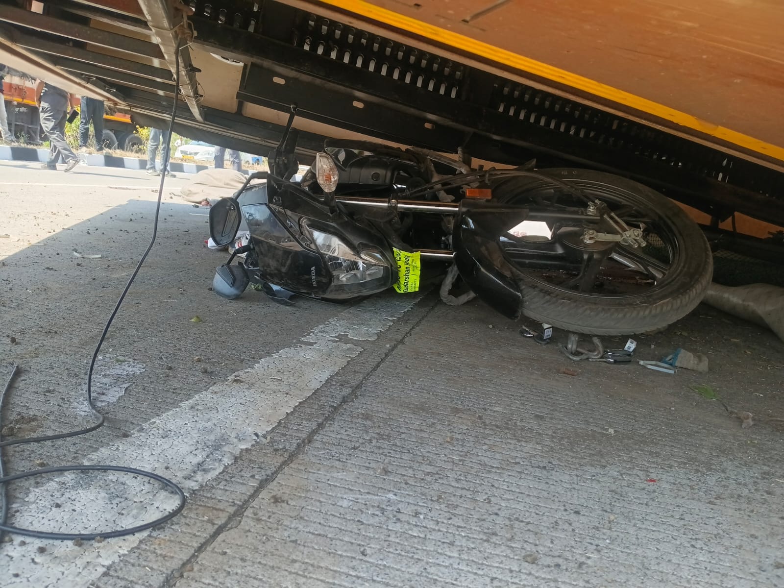 कंटेनर के नीचे दबी बाइक