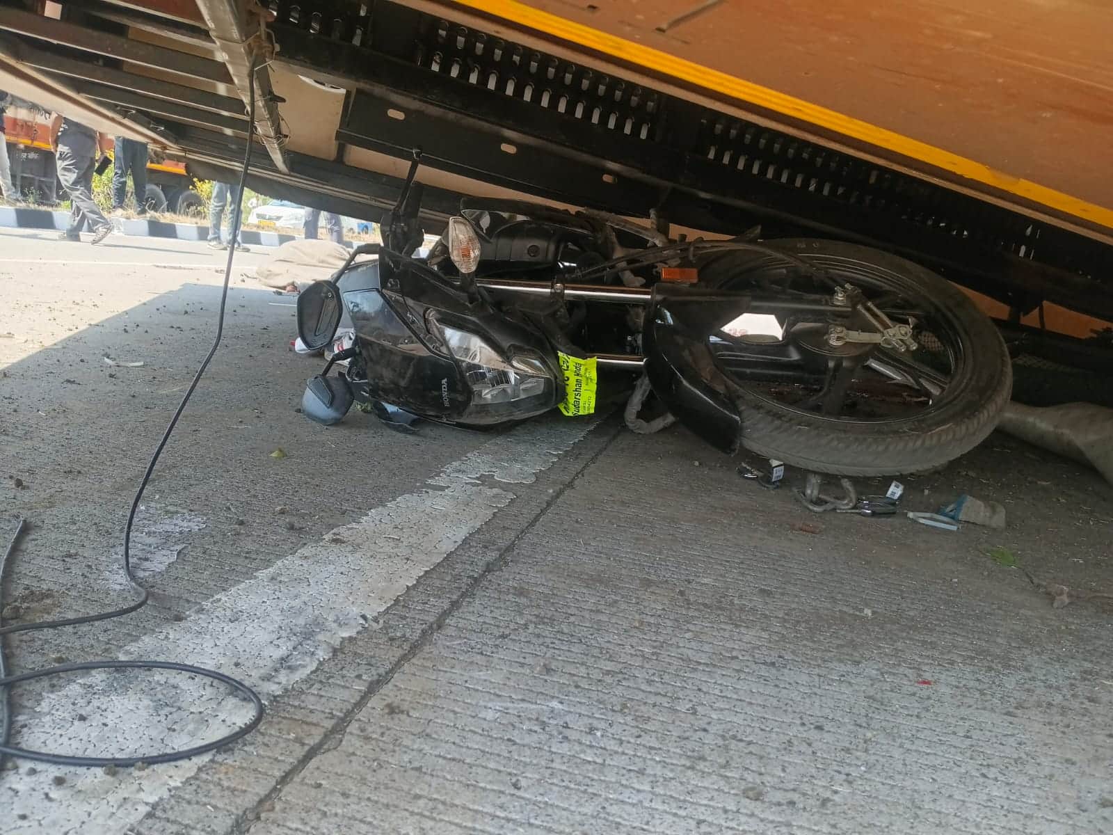 कंटेनर के नीचे दबी बाइक