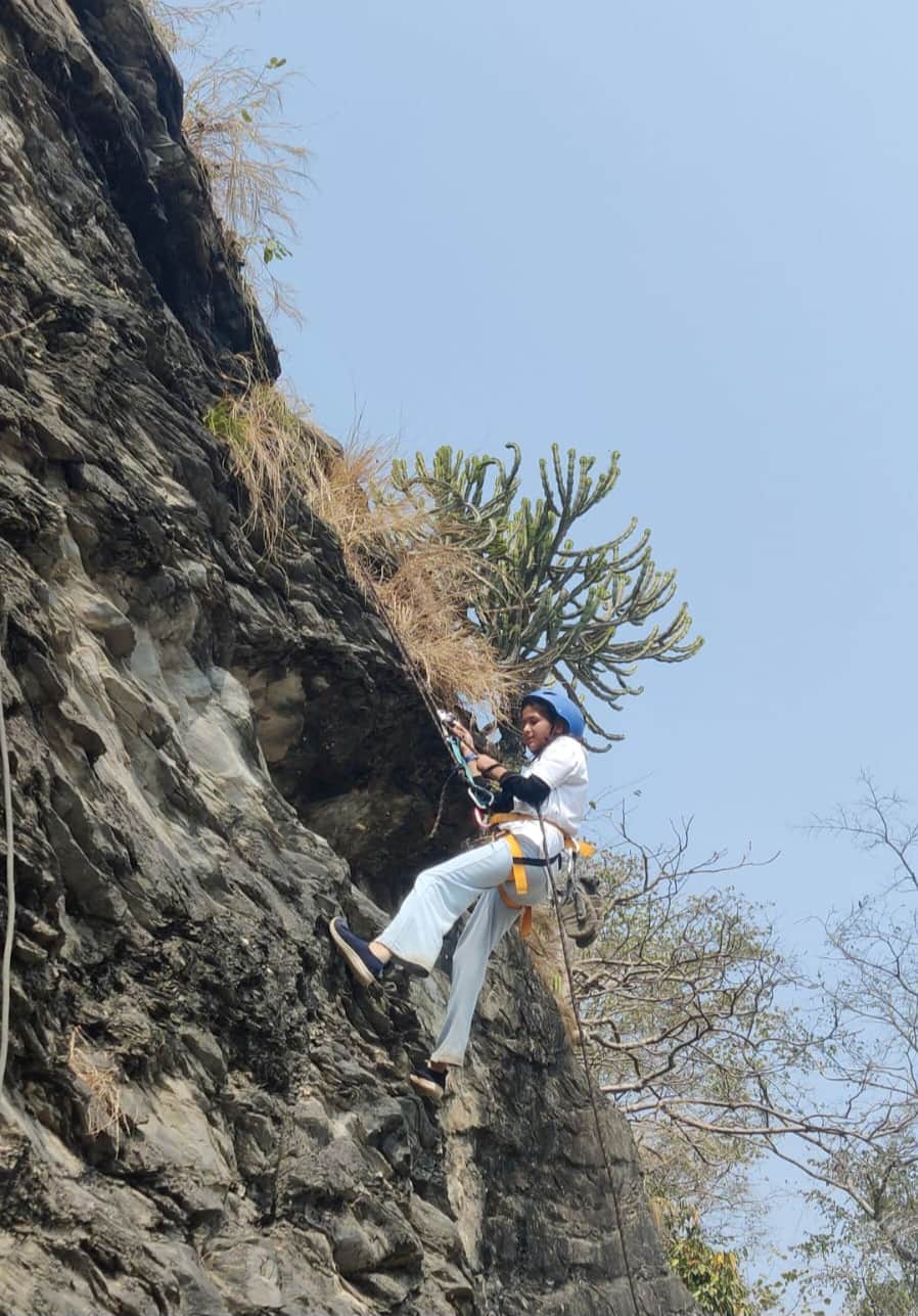 देवप्रयाग में चट्टान आरोहण करती युवती l संवाद