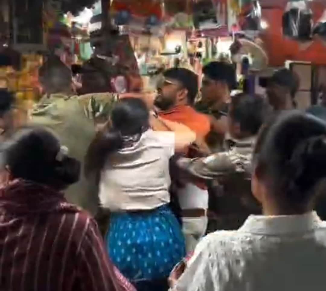 मंदिर परिसर में श्रद्धालु युवक के साथ मारपीट करती पुलिस।