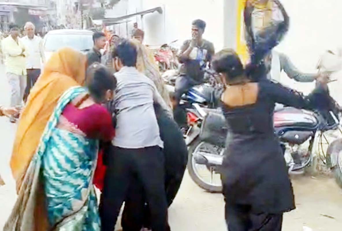 Family members beat up a woman living with her lover at the police station gate.