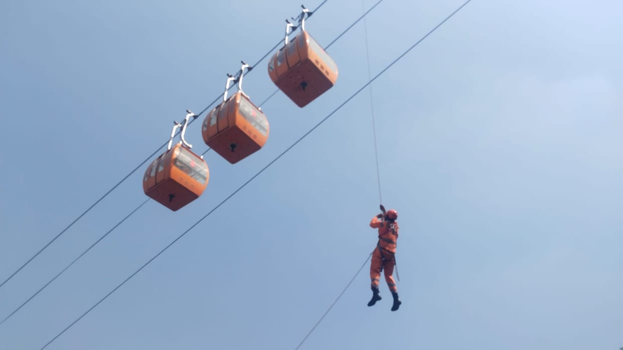 Laxman Jhula ropeway trolleys hang in the air, passengers scream