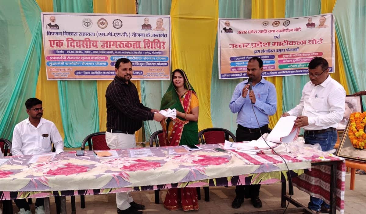 खादी ग्रामोद्योग की तरफ से आयोजित जागरुकता शिविर में ग्राम प्रधान रेशू पटेल को सम्मानित करते अ