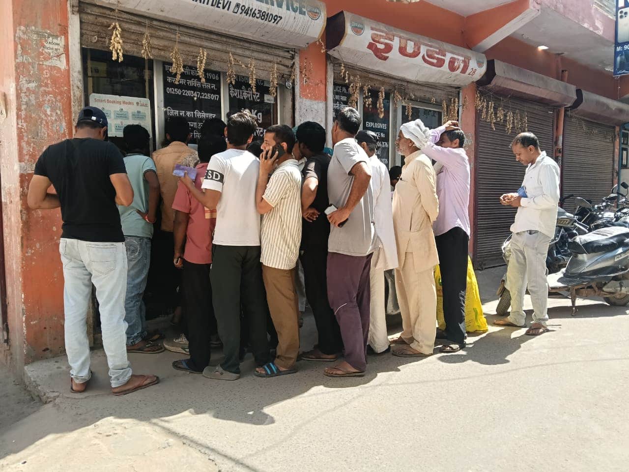 गैस एजेंसी के बाहर सिलिंडर की बुकिंग करवाने के लिए कतार में खड़े उपभोक्ता। 