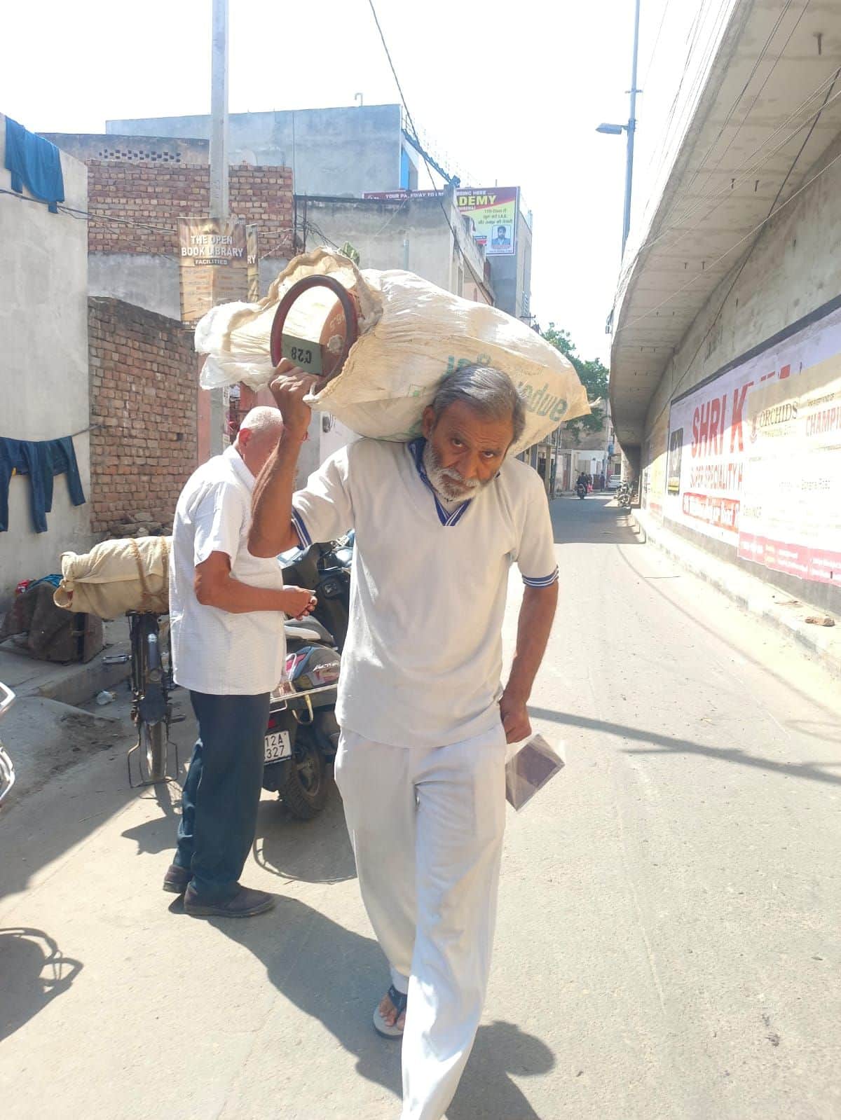 25-कंधाें पर सिलिंडर उठाकर गैस एजेंसी में पहुंचते हुए उपभोक्ता। संवाद