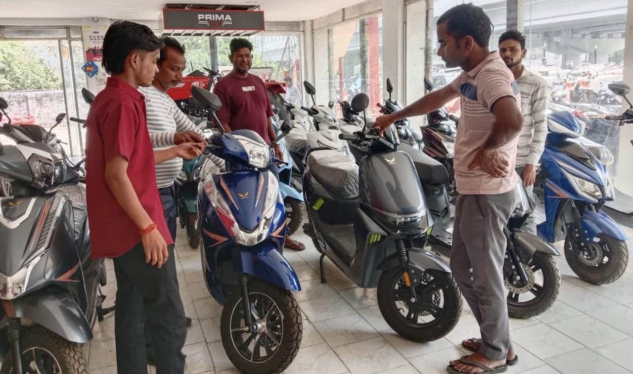 ई बाइक शो रूम पर बैटरी वाली स्कूटी की खरीदारी करते लोग। संवाद