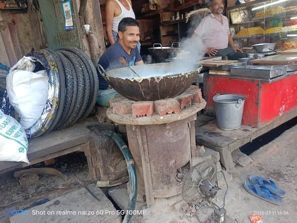 शहर में एक मिठाई की दुकान पर कोयले की भट्ठी पर तैयार होती मिठाई। संवाद