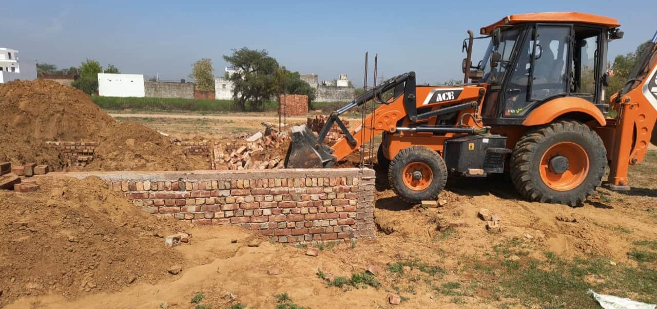 अवैध कॉलोनी में निर्माण को तोड़ती जेसीबी मशीन।