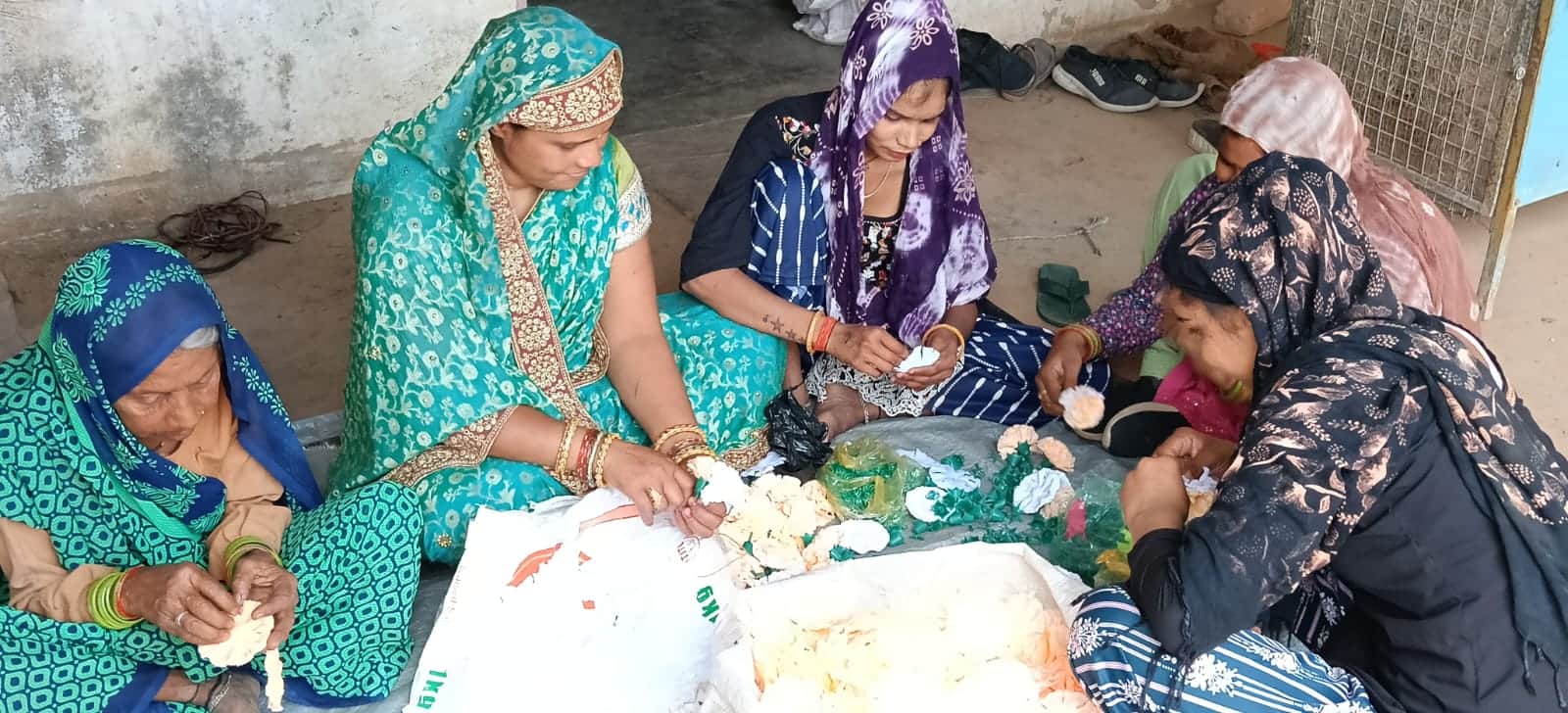 गांव गारवगढ़ी में कृत्रिम फूलों की झालर बनातीं महिलाएं। संवाद