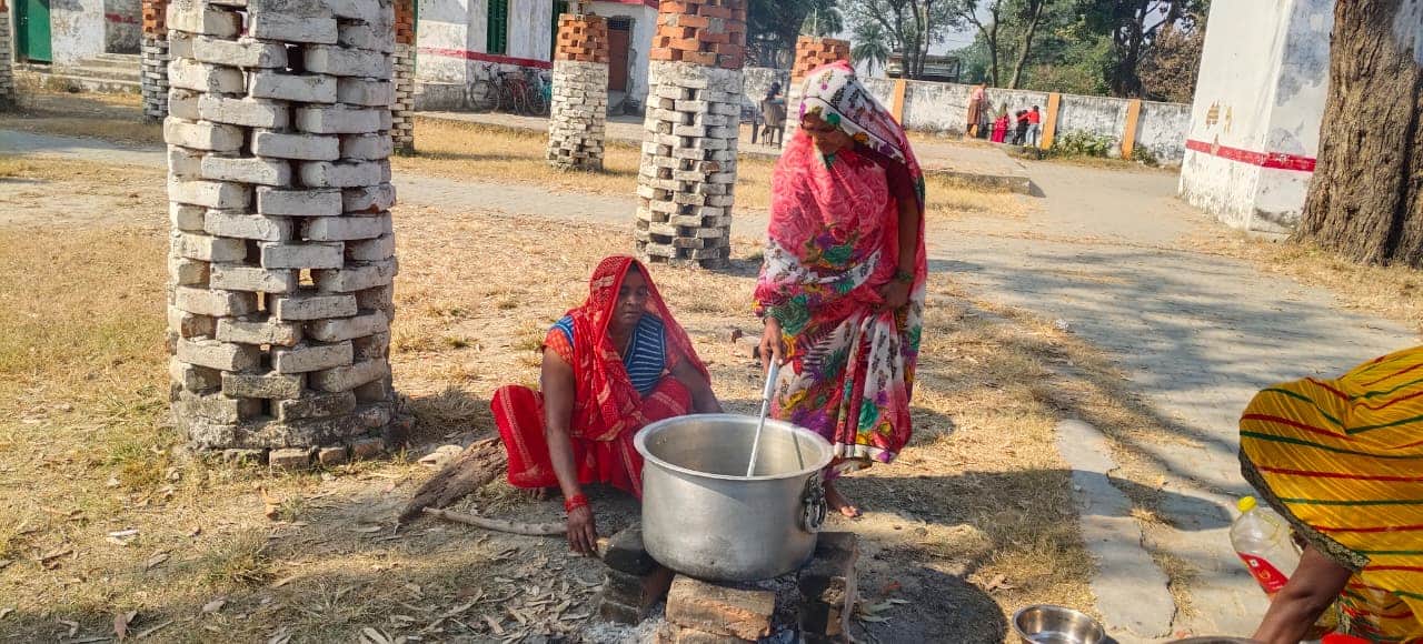 सेमरियावां क्षेत्र के एक स्कूल में लकड़ी से मध्यान्ह भोजन बनातीं रसोईया।  
