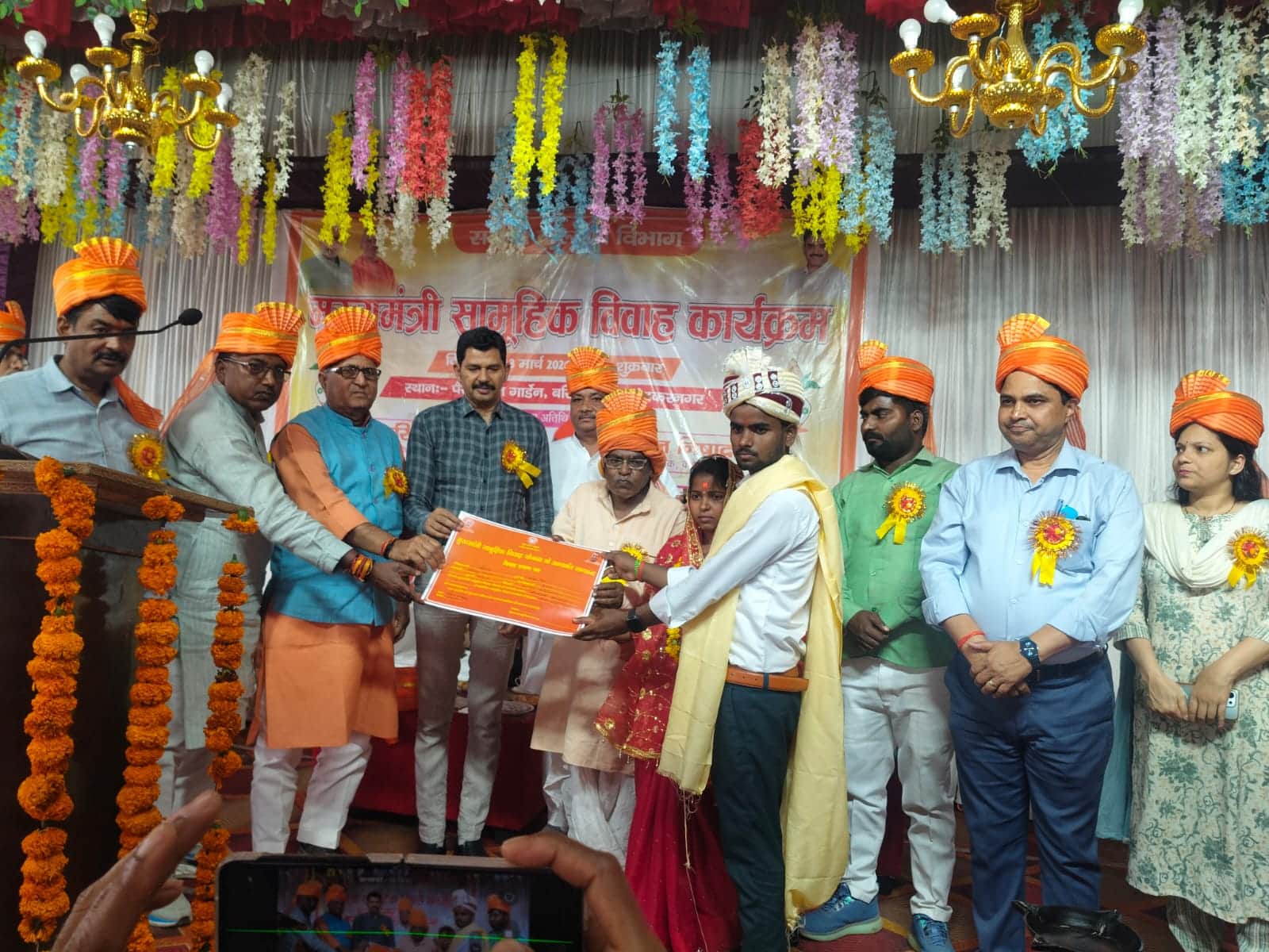 स्थित एक मैरिज हाल में वर वधू को प्रमाण पत्र देते जिला पंचायत अध्यक्ष, सीडीओ व अन्य।