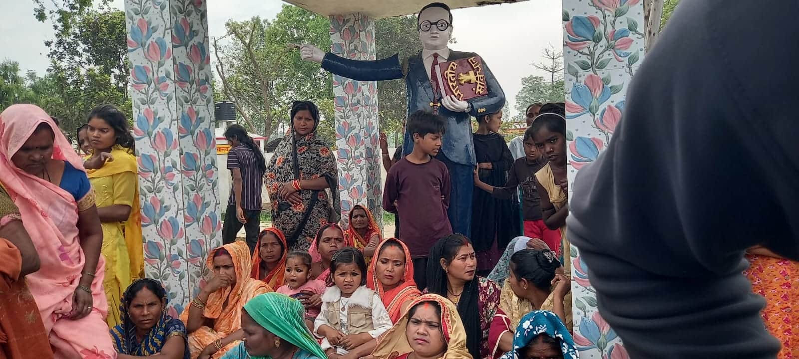 आंबेडकर प्रतिमा के पास बैठे अनुयाई और ग्रामीणों को समझाते सीओ। स्रोत : ग्रामीण