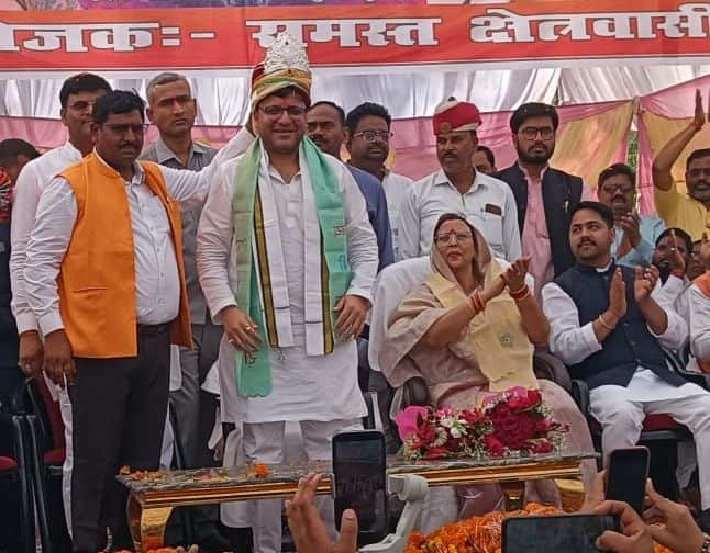 फोटो-47-सुमई में समारोह के दौरान आबकारी मंत्री नितिन अग्रवाल को चांदी का मुकुट पहनाते आयोजक राम