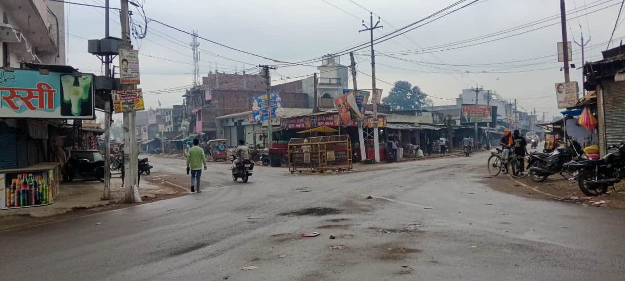 बदला चौराहे पर बूंदाबांदी के बीच निकलते लोग।