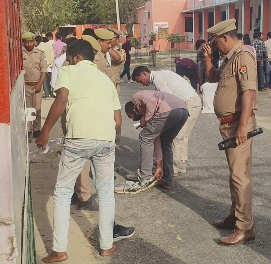 जीआईसी में परीक्षार्थियों के जूते उतरवाकर चेकिंग करते पुलिस कर्मी।