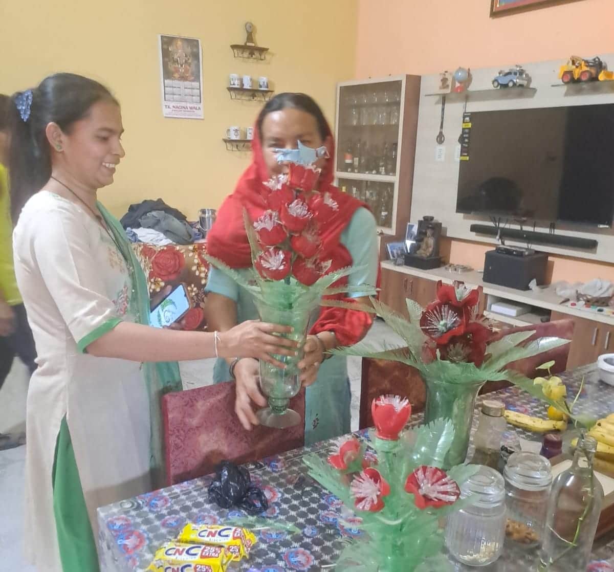 जमुना देवी द्वारा बनाई वस्तुओं को देखते हुए स्वच्छ भारत मिशन इंचार्ज ज्योति शर्मा।