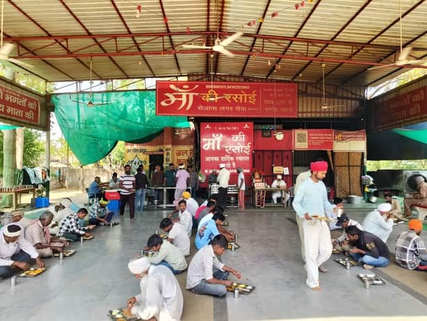 मां की रसोई में खाना खाते हुए जरूरतमंद लोग :संवाद