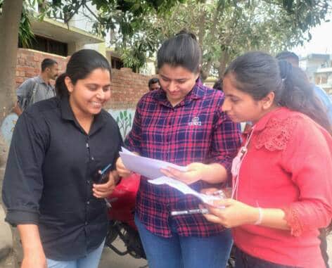 परीक्षा देने के बाद उत्तरों का मिलान करती हुईं महिला अभ्यर्थी स्रोत संवाद