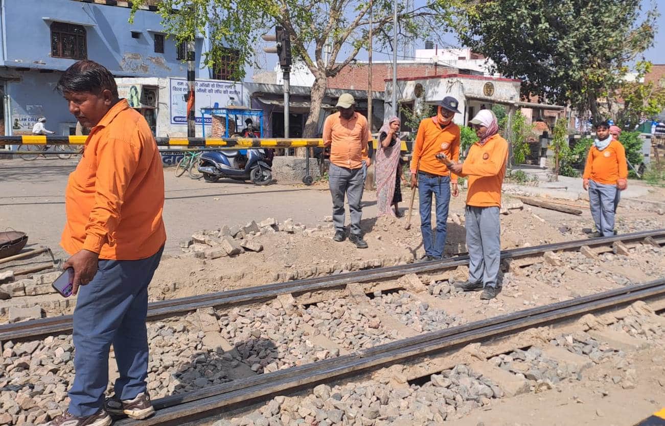 रेलवे ट्रैक पर मरम्मत कार्य करते कर्मी। संवाद