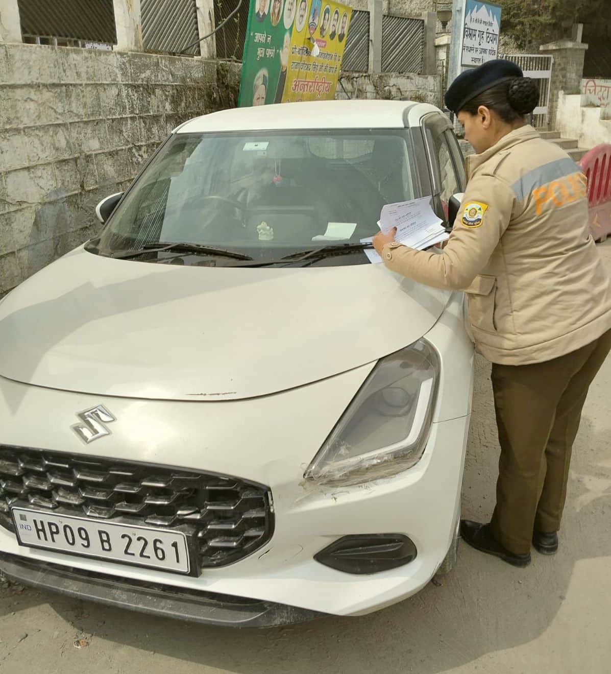 रेस्ट हाउस ठियोग के सामने पार्क हुए वाहनों पर वार्निंग स्लिप लगाती पुलिस कर्मी। संवाद